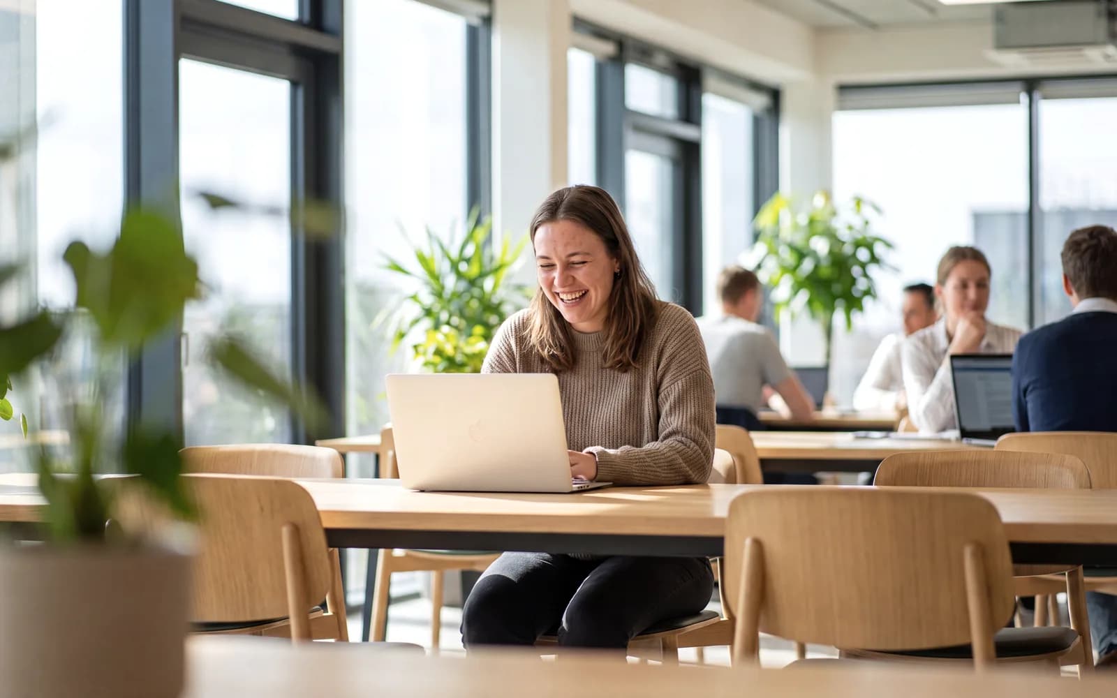 Young professional laughing at work in a bright office