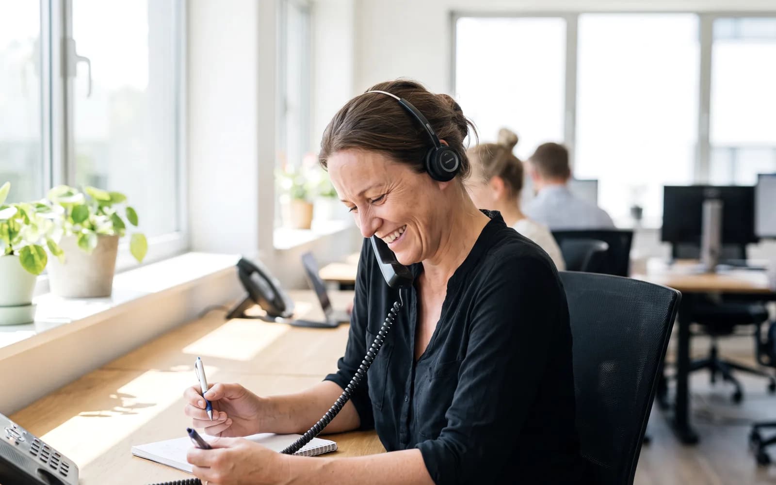 Woman on a warm phone conversation wearing a headset